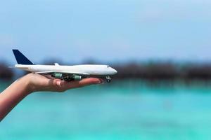 close-up de uma mão segurando um avião de brinquedo