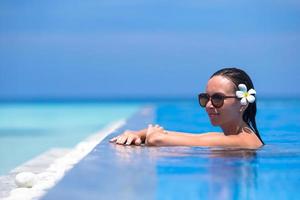 mulher curtindo uma piscina perto da praia foto