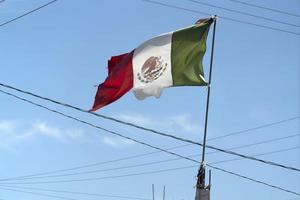 bandeira mexicana rasgada acenando entre fios foto