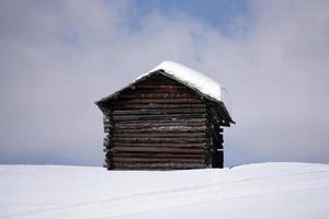 cabana de madeira no fundo da neve do inverno foto