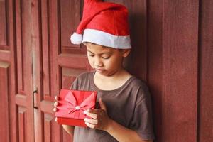 menino com caixa de presente no dia de natal foto