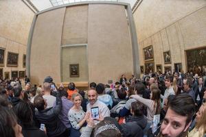 Paris, França - 30 de abril de 2016 - Mona Lisa Painting Louvre Hall lotado de turistas foto