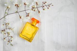 frascos de perfume e flores em um lindo fundo branco foto