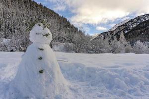 boneco de neve na paisagem alpina foto