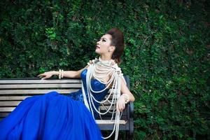 bela dama de vestido azul de luxo com pérola foto