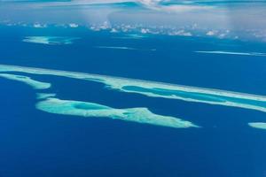 vista aérea do resort maldivas, destino de viagem de luxo. vista panorâmica do mar azul profundo, reed coral, ilha tropical. incrível vista da natureza, paisagem aérea drone foto