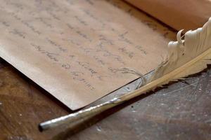 pluma e carta escrita à mão foto