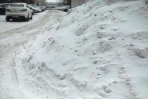 neve no estacionamento. monte de neve na estrada. após a tempestade de neve. foto