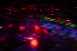 pista de dança discoteca. luz na pista de dança. manchas coloridas no chão. luzes dos holofotes. foto