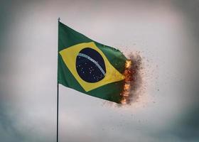 bandeira do brasil acenando em um poste com fogo e fumaça nas bordas, composição digital foto