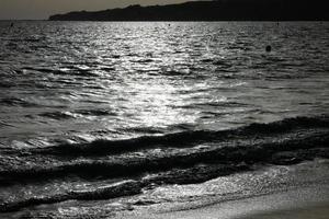 praia deserta e deserta com mar calmo e ondas pequenas foto