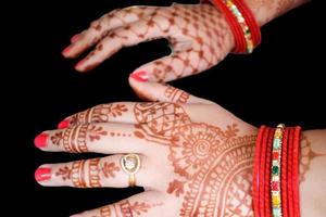 mulher bonita vestida como tradição indiana com henna mehndi design em ambas as mãos para celebrar o grande festival de karwa chauth com fundo branco liso foto