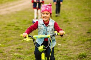 três crianças felizes andando de bicicleta foto