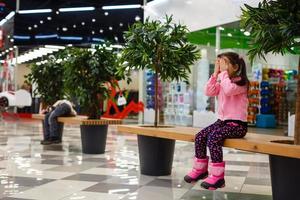 adorável menina está chorando no shopping foto