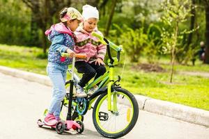 namorada feliz andar de patins scooter e bicicleta a reboque rindo alegremente foto