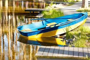 barco de pesca em águas calmas do lago, velho barco de pesca de madeira, barco de pesca de madeira em águas calmas do lago foto