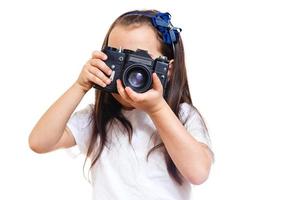 menina tirando uma foto com uma câmera retrô profissional isolada no branco
