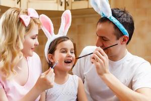 mãe pai e filha estão pintando ovos família feliz está se preparando para a páscoa foto