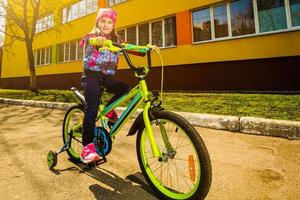 criança em uma bicicleta na estrada asfaltada foto