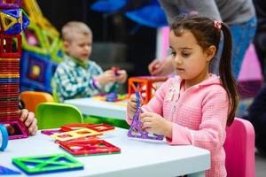 criança bonita brincando com brinquedo construtor magnético foto