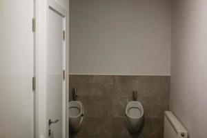 banheiro público mictório de banheiro masculino conforto mictório branco em banheiro público água foto