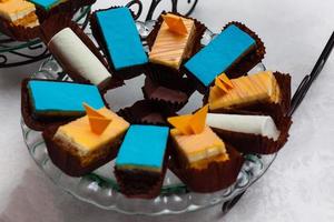 cupcakes com creme amarelo e azul em um prato branco foto