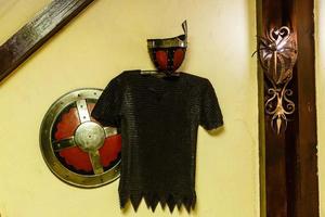 armadura de cavaleiro com espadas na parede de madeira no castelo foto