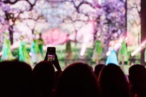 um smartphone segurado com as duas mãos para filmar durante um show. foto