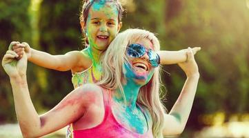 mãe e filha brincando no festival de tintas foto