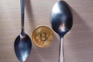 moeda digital moeda física de bitcoin de prata no conceito de cozinha de colher foto