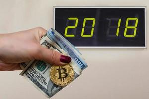 moeda de bitcoin dourada na mão de mulheres em notas de dólar turva espaço de cópia de fundo 2018, cão de barro foto