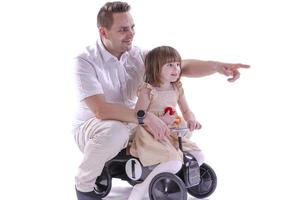 menina e seu pai andando de carro de brinquedo estilo retrô. foto