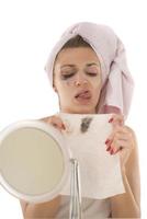 mulher limpando removendo a maquiagem do rosto com um guardanapo molhado foto