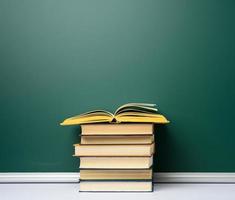 conselho escolar de giz verde em branco e pilha de livros, de volta à escola foto