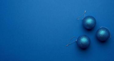 bolas de natal brilhantes azuis sobre um fundo azul, pano de fundo festivo foto