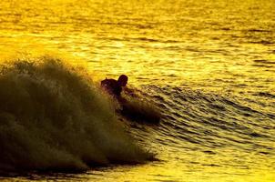 surfista sobre o pôr do sol foto