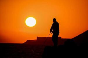 pescador sobre o pôr do sol foto