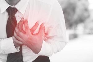 homem com dor no peito - ataque cardíaco ao ar livre. ou exercício pesado faz com que o corpo sofra doenças cardíacas. foto
