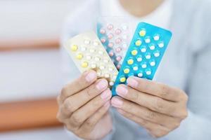 mãos de mulher abrindo pílulas anticoncepcionais na mão. comendo pílula anticoncepcional. contracepção reduz o conceito de parto e gravidez. foto