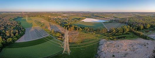 imagem panorâmica da estrada de alta tensão com postes de alta potência à luz da noite foto