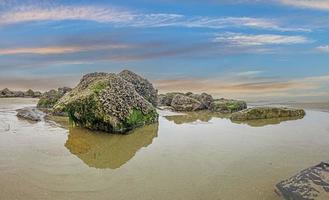 imagem panorâmica de rochas durante a maré baixa na costa do mar do norte da bélgica foto