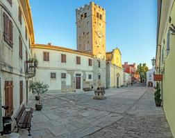 panorama sobre a praça central de motovun com st. a igreja de estêvão e o portão da cidade ao nascer do sol foto