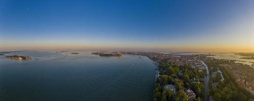 panorama aéreo da lagoa de veneza e ilha de lido durante o nascer do sol foto