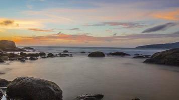 foto de longa exposição do pôr do sol colorido na praia de kamala, na tailândia, no verão