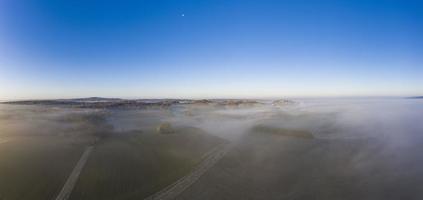 imagem de drone da névoa matinal sobre campos na província alemã de hesse do norte, perto da vila de rhoden foto