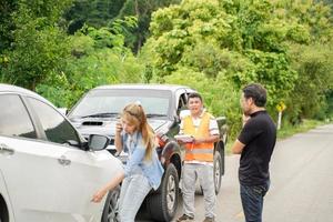 os motoristas ficaram discutindo depois que o carro bateu com o oficial da companhia de seguros verificando os danos do carro na estrada rural. foto
