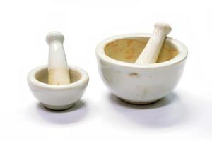 ervas e argamassas de medicina branca, feitas por cal ou cerâmica em fundo branco. foto