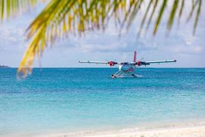 hidroavião no resort de praia tropical. destino de viagem de verão de luxo com hidroavião nas ilhas maldivas. férias exóticas ou transporte de férias, mar das maldivas foto