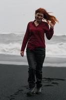 mulher com cabelo bagunçado na fotografia cênica de praia negra