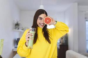 linda mulher segurando o copo de smoothie e toranja. estilo de vida saudável. dieta de alimentos crus, nutrição vegetariana, refeição de desintoxicação orgânica foto